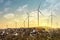 View of a wind turbines on top of garbage mountains, dramatic sunset sky. Green energy concept