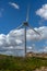 View of a wind turbines on top of mountains, dirt road and wild nature and landscape