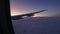 View from window of airplane during flight above clouds at dawn