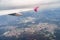 View from the window of a flying plane on the city, roads, green forest, fields