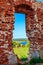 View through window hole of ruined red brick building