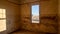 View through the window of one of the houses in the ghost town of Kolmanskop, Namibia. The inner walls are cracked and paint are
