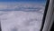 View from the Window of the Plane at the Clouds. Airplane flies above the weather