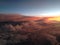 The view from the window of the plane to fantastically beautiful sunset above the clouds