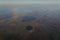 View from the window of the plane to the horizon of the lake and the river in the mountains with forests at sunset of the day