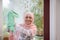 View through a window with smudges of cleansing detergent to a Muslim Arab woman with covered head in hijab removing stains and