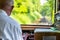 A view from the window of a traveling railroad train, a visible engine driver running a train, dashboard, tracks, trees and a blue