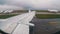 View from the Window on the Wing of an Airplane moving along the Runway at Airport