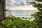 View from window of wooden hut on lush vegetation and beach on Caribbean Sea Jamaica