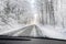 View through the windscreen when driving dangerously on a slippery forest road in the snow, copy space