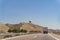 View from windshield of a car on desert road with truck and sign of spanish bull