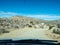 View through windshield on dirt desert road with yuccas blue sky sun in Yucca Valley California near Joshua Tree National Park