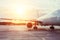 View of the wing and engine of a long-range passenger aircraft, evening airport at sunset