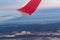 View of the winter city from a height of flight from the window of an airplane with a silvery red wing