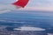 View of the winter city from a height of flight from the window of an airplane with a silvery red wing