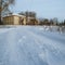 View of the winter road and old two-storeyed beige house