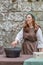 View of a witch performing in medieval market, actress dressed in witch\'s robes and cooking magic potion