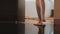 View of woman elegantly walk to bathroom open door and sit down on bath.