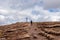 view of woman with hiking backpack reaching summit cross of mountain peak Gertrusk, Saualpe, Lavanttal Alps, Carinthia, Austria