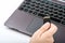 View of a woman holding a black SD card in her hand. Silver laptop or computer with black keyboard -  on white background