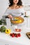 View of woman putting sliced yellow paprika in glass bowl