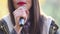 View of woman\'s mouth with red lipstick, smiling and singing with microphone