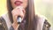 View of woman\'s mouth with red lipstick, smiling and singing with microphone
