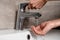 View of woman touching faucet and washing hand in bathroom