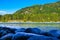 View of the wooded mountain and flowing blue river