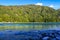 View of the wooded mountain and flowing blue river