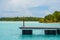 View of a wooden dock jutting out into a body of water from the edge of a coastline