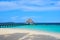 View of wooden path leading to bungalow style deck on turquoise ocean of the Coco Bodu Hithi resort in Maldives