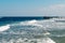 View of a wooden pier on the tropical seashore with blue sky and sea.