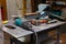 View of a workbench with a set of tools consisting of a large heavy vise, angle grinder, screwdriver, cutter, sledgehammer, and a