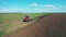 View of a working tractor, plowing field.