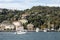 View of a yacht passing on Bosphorus and Bebek neighborhood on European side of Istanbul. It is a sunny summer day.