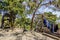 View of a yellow abandoned freight bicycle on an arid lot with blue clothes hanging