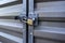 View of a yellow padlock keeping two large metal doors locked up tight in an outdoor storage facility