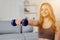 View of a young attractive girl doing exercise at home with dumbells. Healthy lifestyle.