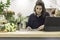 View of a young female florist running a flower shop business and scheduling the agenda in front of a laptop. Businesswoman