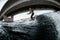 View on young male wakesurfer in wetsuit on surfboard who rides on the wave.