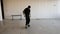 View of young man dressed in black and skating around on his skateboard in abandoned empty factory building