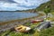 The view at Ytrebukta bay with small boats and fisher huts along the coastline of Porsangerfjorden in Norwegian Finnmark, close to