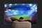 Viewer in front of a large TV relaxed on the armchair at home watching a sports game