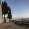 viewpoint of the church of JÃºbar in the Alpujarra with slate stone benches, fences and two pine trees in the background