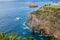 Viewpoint in cliff with rocks in the Atlantic Ocean and leaves, with islets of Mosteiros in the blur background, SÃ£o Miguel - Azo