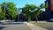 Viewpoint of Downtown City People and Traffic Along Street Surrounded by Buildings in Summer Day.  Urban Cityscape of Road