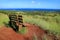 Viewpoint for Hanga Roa and Pacific Ocean with a Wooden Bench on Red Scoria at Puna Pau Volcano, Easter Island, Chile