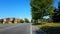 Viewpoint of impatient driver as old woman pedestrian walks across street. Vehicle waits for elderly person walking along road