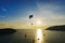 Viewpoint Laempromthep, Phuket, Thailand. Silhouette, Paragliding extreme sport activity and Sailboat tour to watch sunset in the